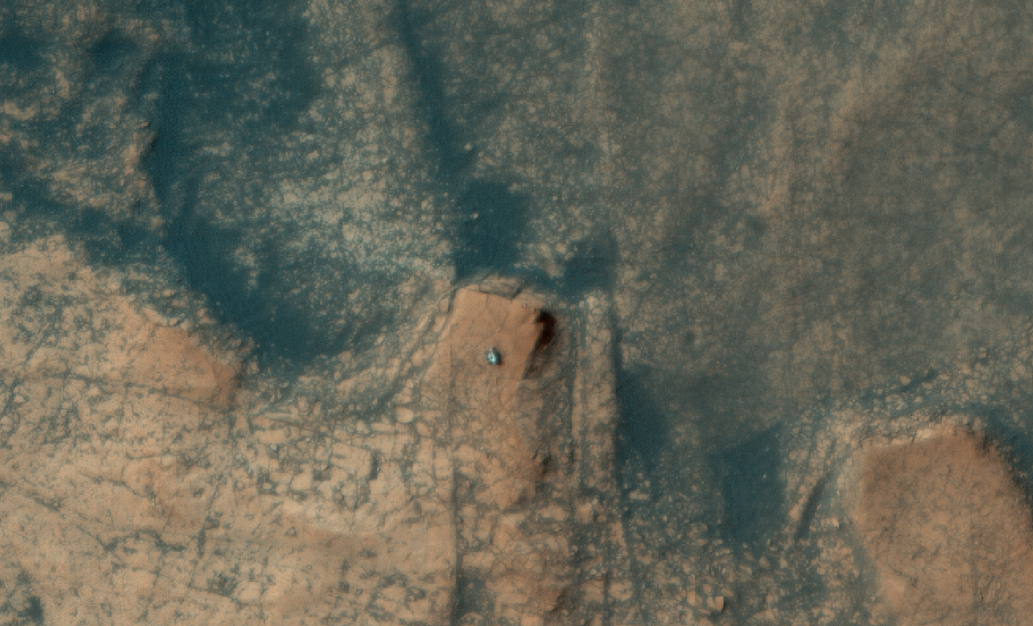 Марсоход Curiosity с ветхими колесами лезет на скалу в кратере Гейл – фото с орбиты