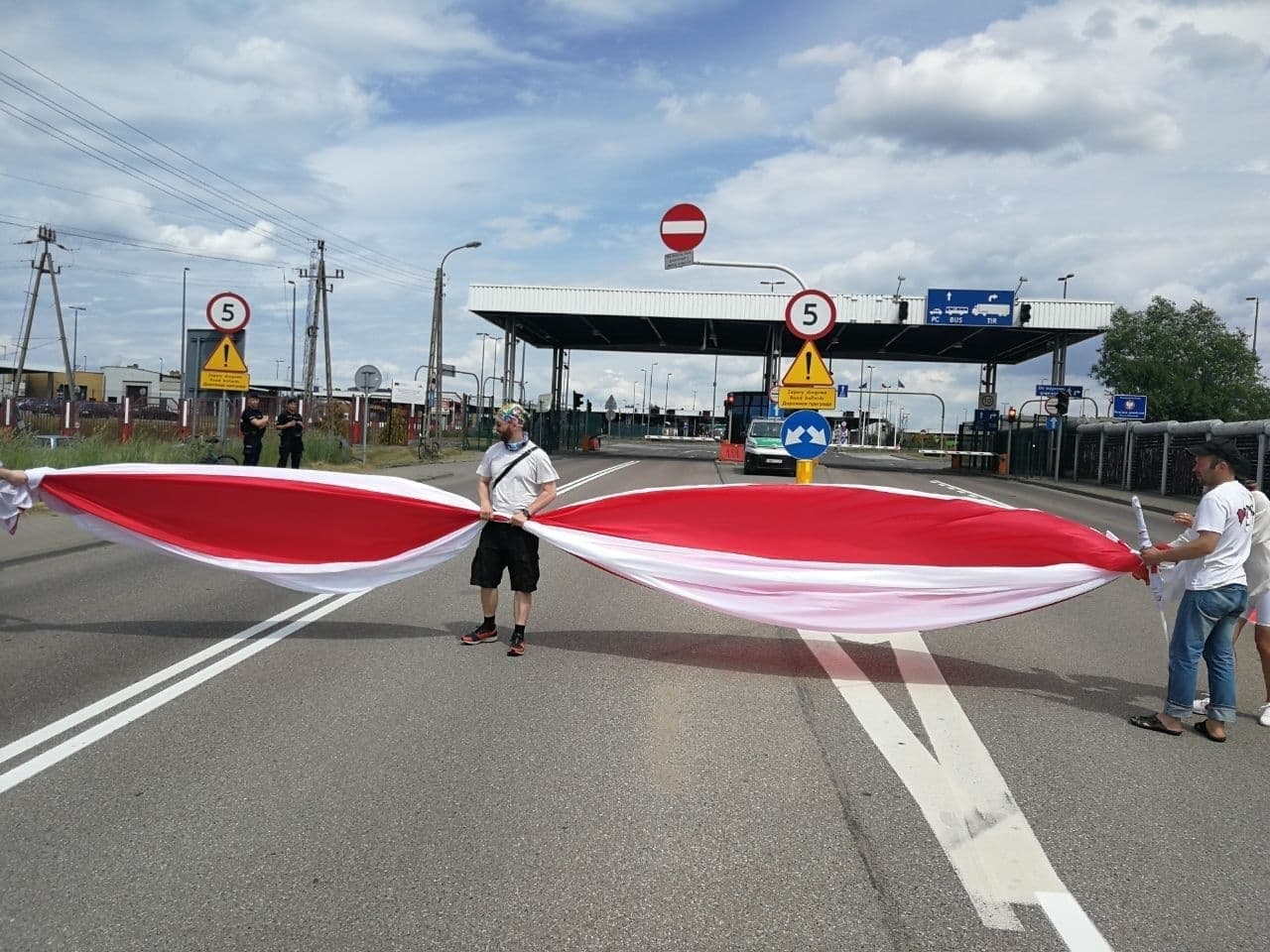 Митингующие с флагом (источник – Telegram tut.by) "Остановите поддержку убийцы". На границе с Беларусью проходят протесты против Лукашенко