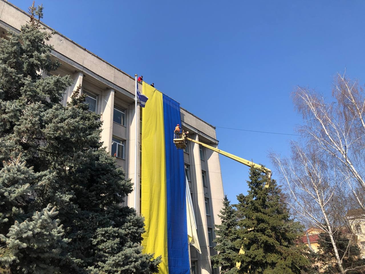 Херсонские коммунальщики вешают украинский флаг на здании горсовета (фото – Игорь Колыхаев)