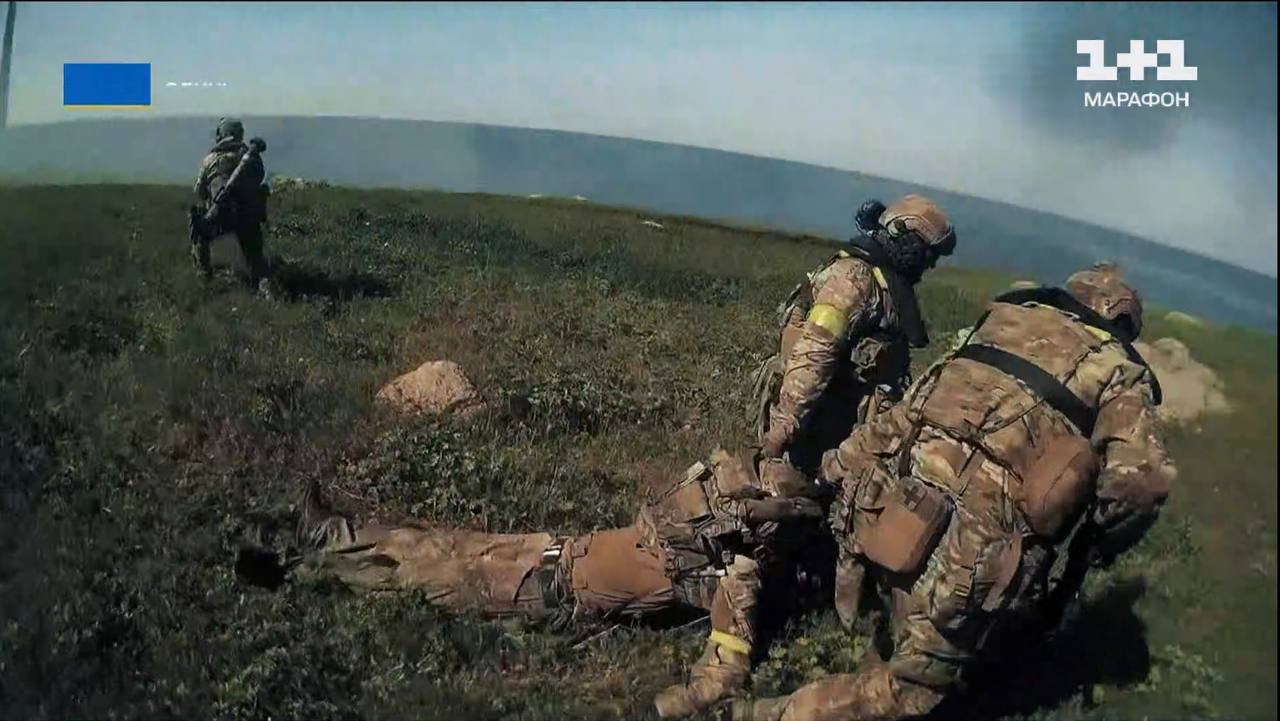 Українські спецпризначенці переміщують пораненого бійця